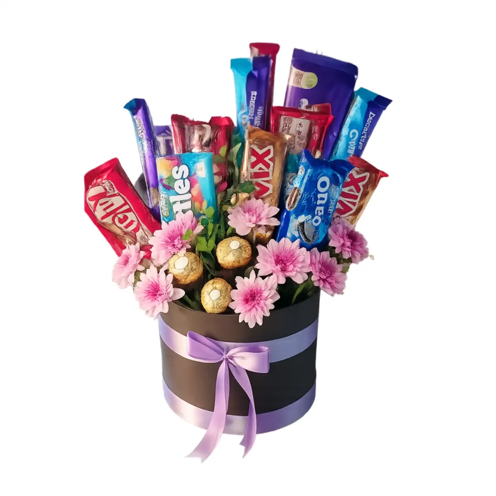 A black box containing assorted chocolates and vibrant flowers, elegantly arranged for a gift presentation.