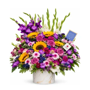 A vibrant bouquet of assorted flowers arranged in a simple white vase, showcasing a variety of colors and textures.