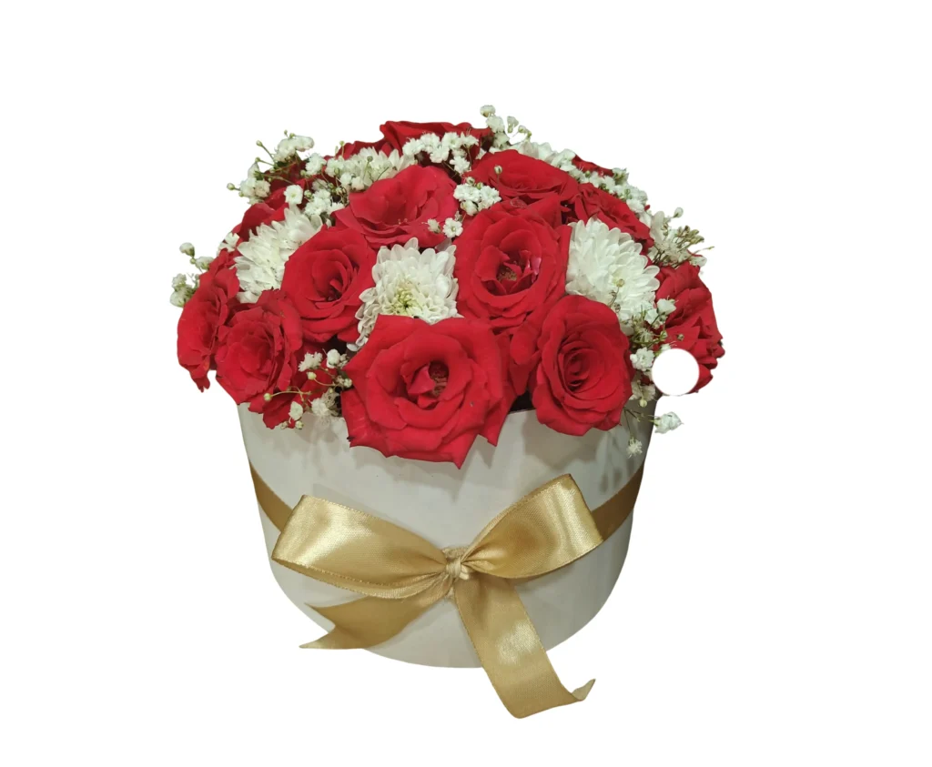 A white box filled with vibrant red roses and delicate white chrysanthemums arranged elegantly.