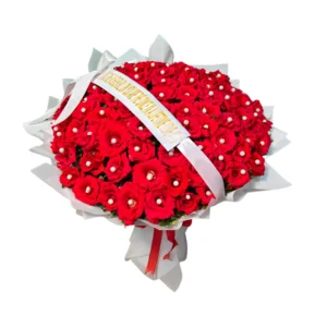 A bouquet of vibrant red roses tied with a decorative ribbon, showcasing their lush petals and green leaves.