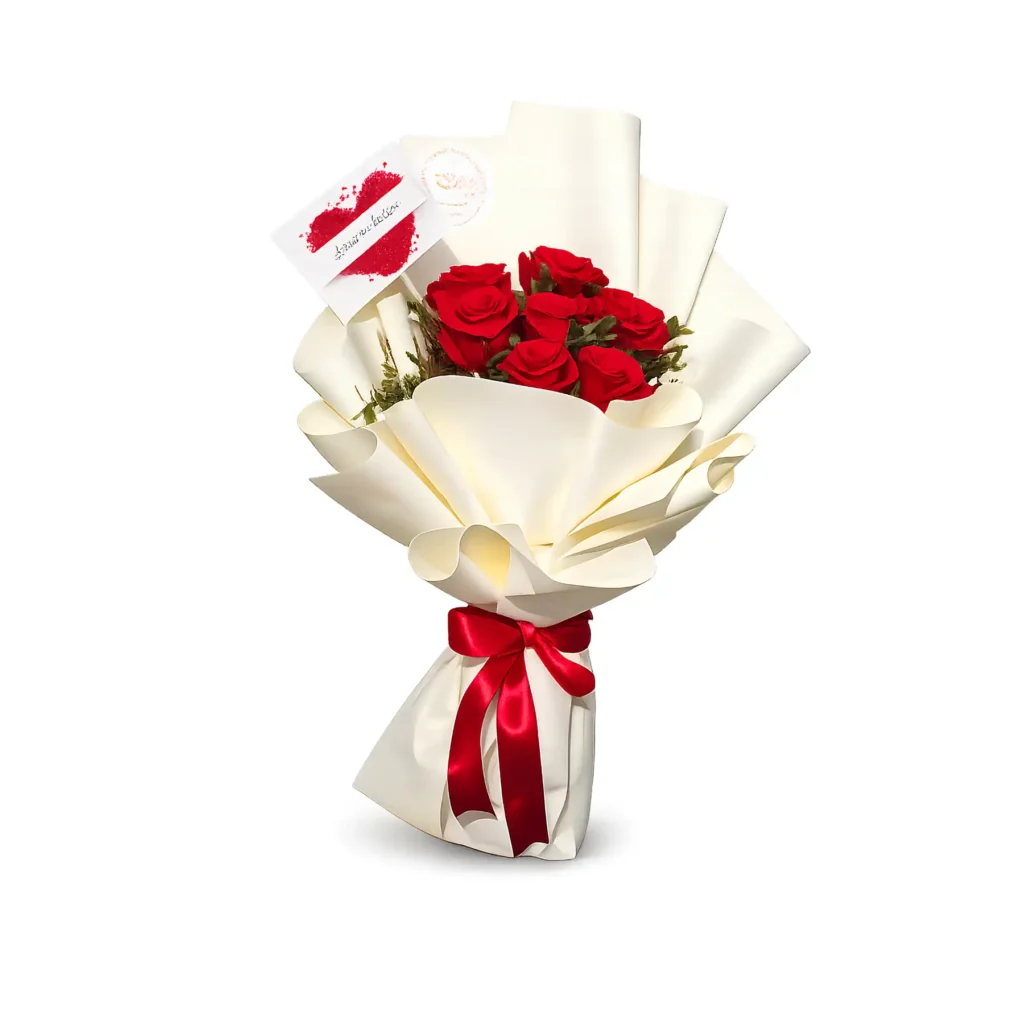A bouquet of vibrant red roses elegantly wrapped in crisp white paper.