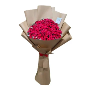 A bouquet of vibrant red roses wrapped in rustic brown paper, showcasing their lush petals and green leaves.