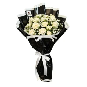 A black and white image of a bouquet of white roses, showcasing their delicate petals and elegant arrangement.